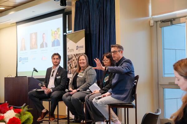 Four panelists speaking at an event.